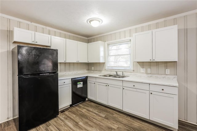 kitchen featuring hardwood / wood-style flooring, white cabinetry, ornamental molding, and black appliances