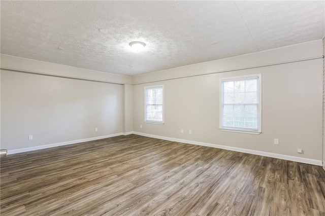 spare room with hardwood / wood-style floors, plenty of natural light, and a textured ceiling