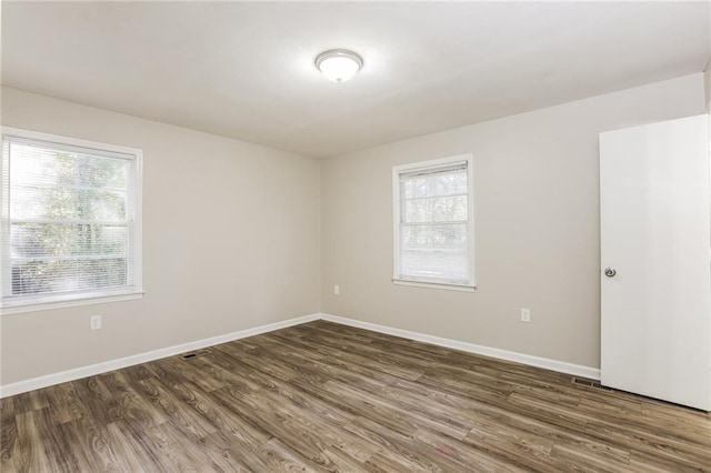 unfurnished room featuring dark wood-type flooring