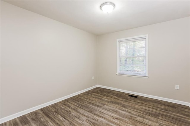 unfurnished room with dark wood-type flooring