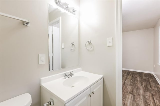 bathroom featuring wood-type flooring, vanity, and toilet