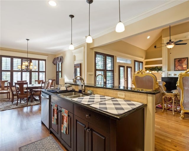 kitchen with a center island with sink, ceiling fan with notable chandelier, hanging light fixtures, stainless steel dishwasher, and dark brown cabinetry