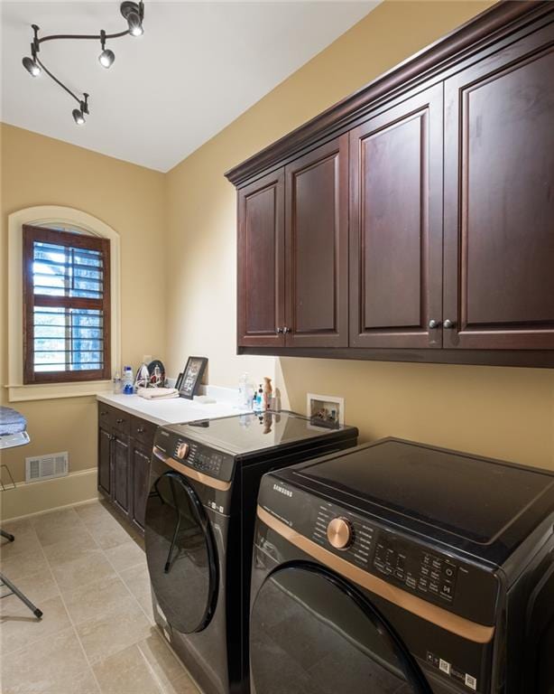 washroom with cabinets, independent washer and dryer, and light tile patterned floors