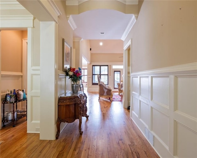 corridor featuring light wood-type flooring and crown molding