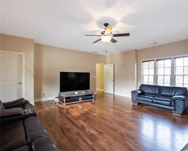 living room with ceiling fan and dark wood-type flooring