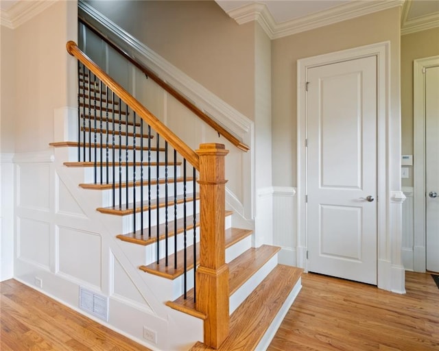 stairway featuring hardwood / wood-style floors and crown molding