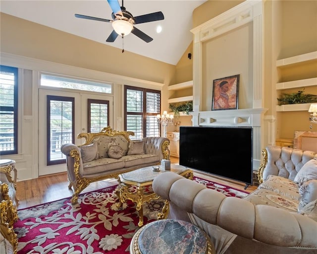 living room featuring built in features, ceiling fan, and a healthy amount of sunlight