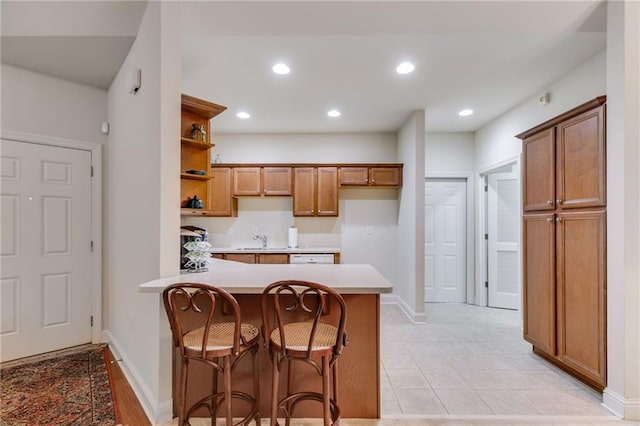 1301 Haven Cir, Douglasville, GA 30135 - kitchen featuring open shelves, a peninsula, light countertops, a breakfast bar, and brown cabinetry