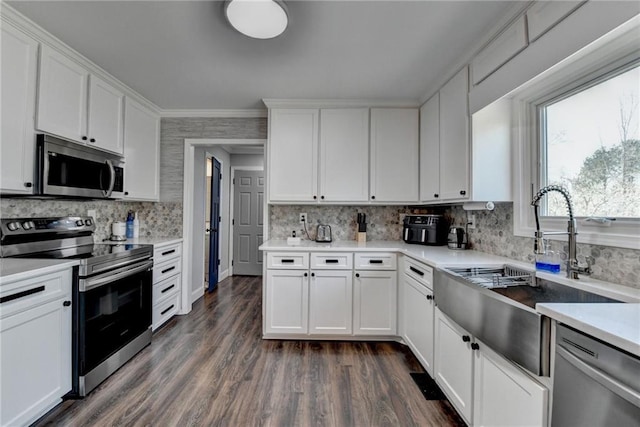 2467 Sky Valley Dr, Dacula, GA 30019 - kitchen with stainless steel appliances, tasteful backsplash, dark wood-style floors, white cabinetry, and crown molding