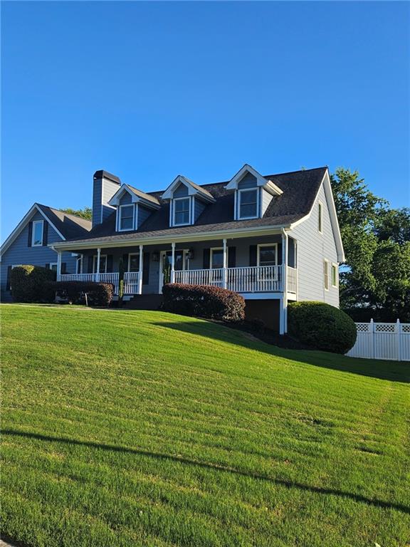 2467 Sky Valley Dr, Dacula, GA 30019 - cape cod house featuring covered porch and a chimney