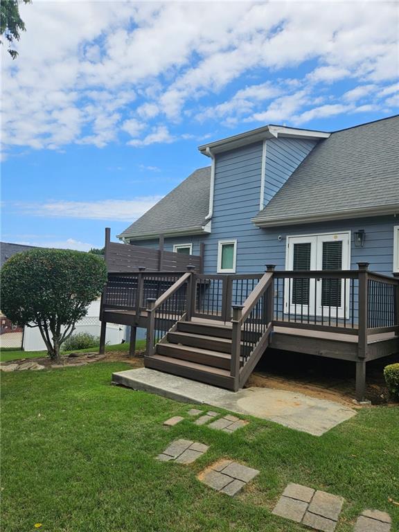 2467 Sky Valley Dr, Dacula, GA 30019 - back of property with a wooden deck, roof with shingles, and a yard