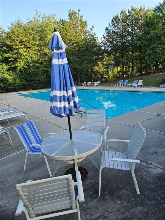 2467 Sky Valley Dr, Dacula, GA 30019 - community pool with a patio and view of wooded area