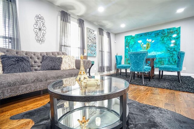 living room featuring baseboards, recessed lighting, wood finished floors, and plenty of natural light