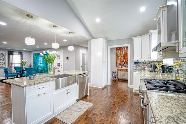 kitchen with white cabinets, a sink, decorative backsplash, wall chimney range hood, and appliances with stainless steel finishes