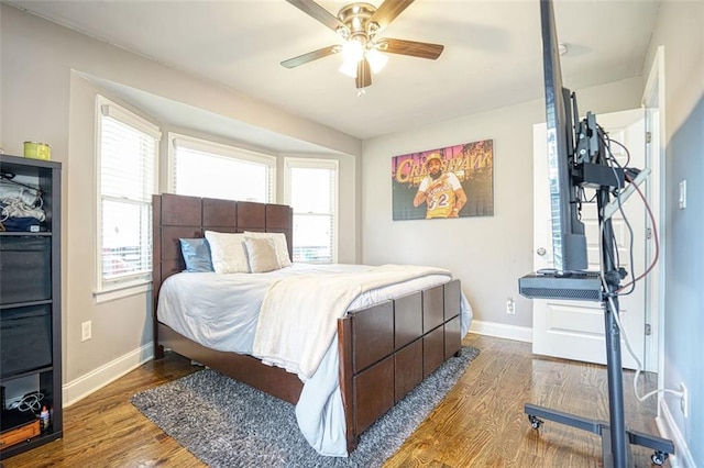 bedroom featuring wood finished floors, a ceiling fan, and baseboards