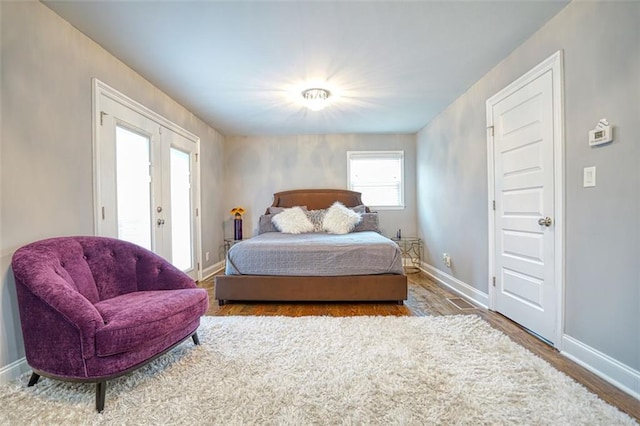 bedroom featuring baseboards, french doors, and wood finished floors