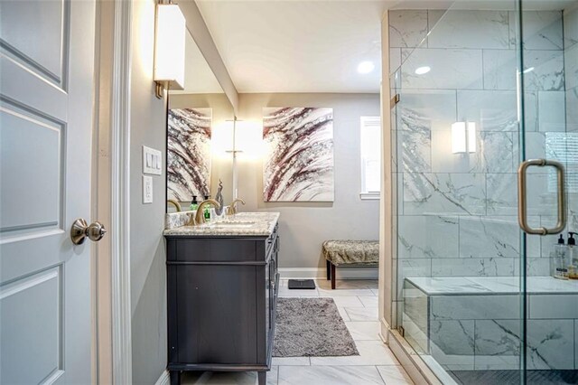 full bathroom with a shower stall, baseboards, marble finish floor, and vanity