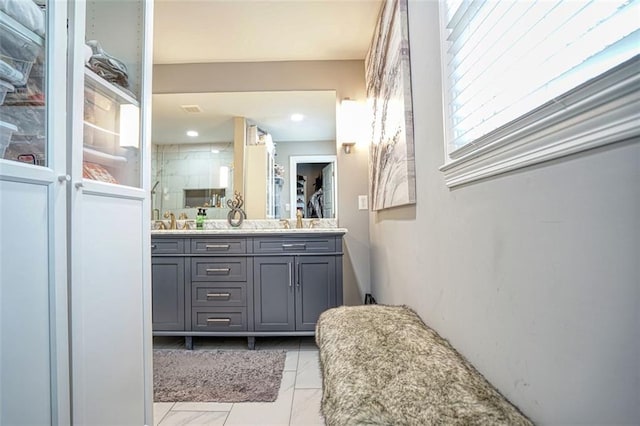 bathroom featuring double vanity, a shower stall, tile patterned floors, and a sink