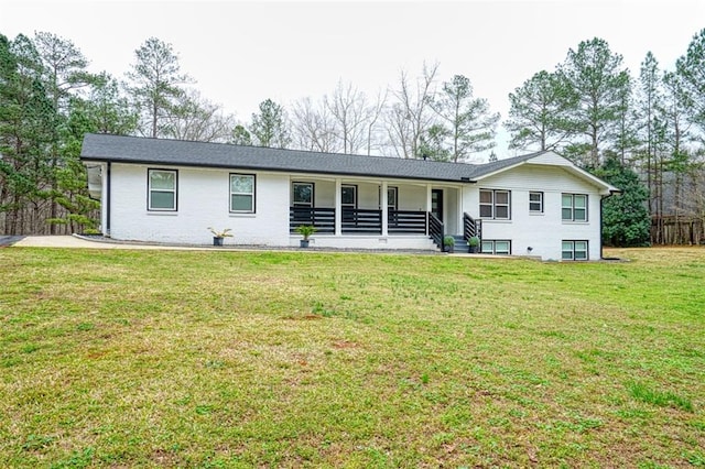 back of house with brick siding, a porch, and a yard