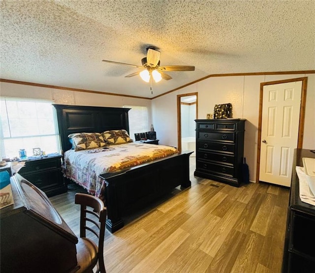 bedroom with ornamental molding, lofted ceiling, a textured ceiling, and light wood finished floors