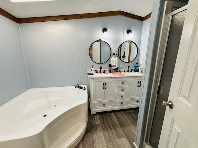 bathroom with double vanity, wood finished floors, a jetted tub, a shower stall, and a sink