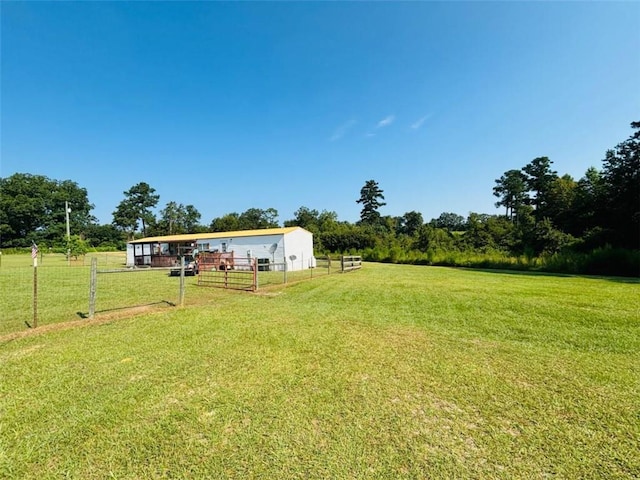 view of yard with an outbuilding, a rural view, and fence