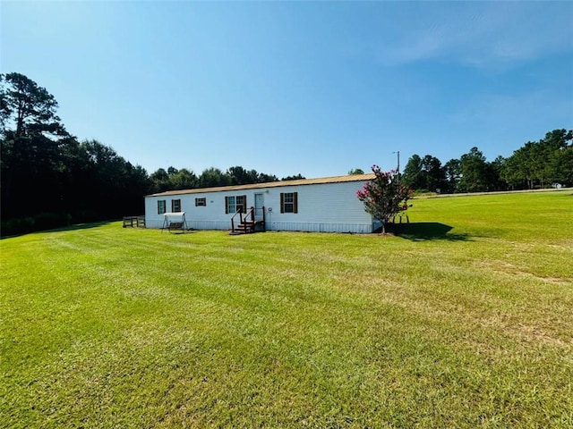 rear view of house with entry steps and a yard