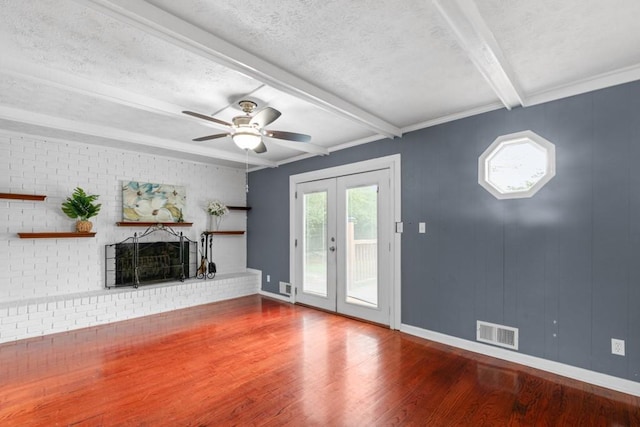 1647 Grandeus Ln SW, Stone Mountain, GA 30087 - unfurnished living room featuring wood finished floors, beamed ceiling, ceiling fan, french doors, and a textured ceiling