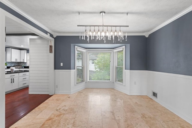 1647 Grandeus Ln SW, Stone Mountain, GA 30087 - unfurnished dining area with a textured ceiling, crown molding, and a chandelier