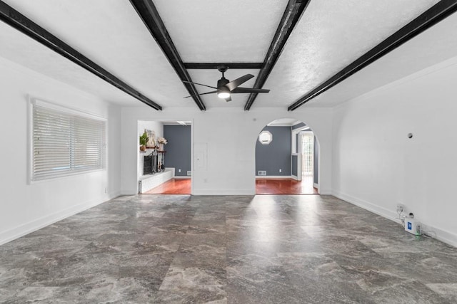 1647 Grandeus Ln SW, Stone Mountain, GA 30087 - unfurnished living room with arched walkways, ceiling fan, beam ceiling, and baseboards