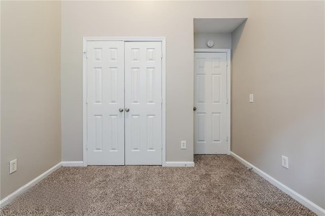 unfurnished bedroom featuring carpet, a closet, and baseboards