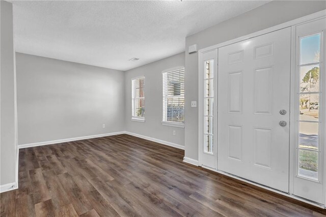 unfurnished living room with ceiling fan, dark wood-type flooring, and a textured ceiling