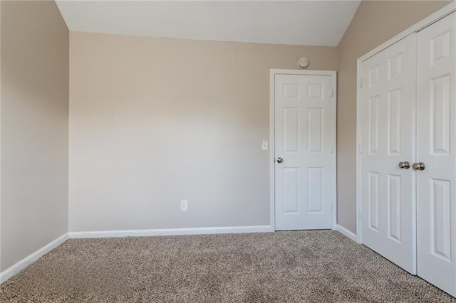 unfurnished bedroom featuring carpet floors, baseboards, and a closet