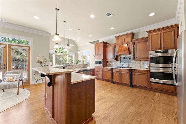 4729 Deer Creek Ct, Flowery Branch, GA 30542 - kitchen featuring appliances with stainless steel finishes, a sink, brown cabinetry, decorative backsplash, and light wood-type flooring