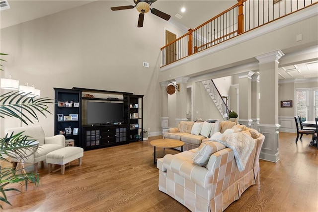 4729 Deer Creek Ct, Flowery Branch, GA 30542 - living room with decorative columns, a ceiling fan, wood finished floors, stairway, and a high ceiling
