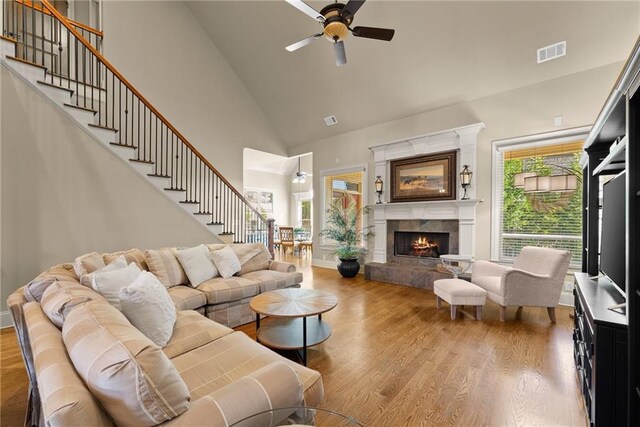 4729 Deer Creek Ct, Flowery Branch, GA 30542 - living room with ceiling fan, wood finished floors, stairway, high vaulted ceiling, and a tiled fireplace