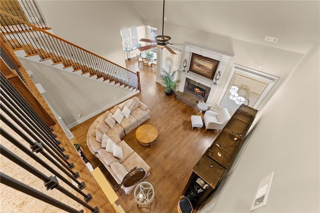 4729 Deer Creek Ct, Flowery Branch, GA 30542 - living area featuring wood finished floors, ceiling fan, a premium fireplace, stairs, and high vaulted ceiling