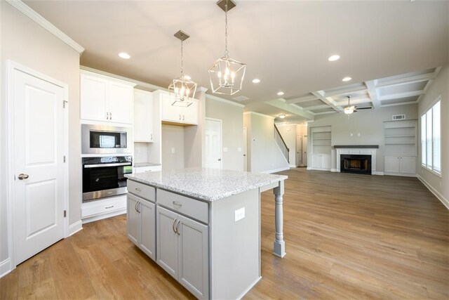 8245 Dawson View Way, Cumming, GA 30028 - kitchen with appliances with stainless steel finishes, recessed lighting, light wood finished floors, a premium fireplace, and a kitchen breakfast bar