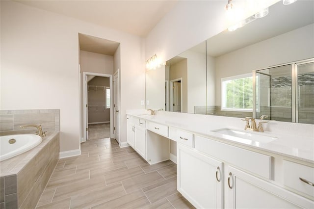 8245 Dawson View Way, Cumming, GA 30028 - bathroom featuring double vanity, a shower stall, a walk in closet, a garden tub, and baseboards