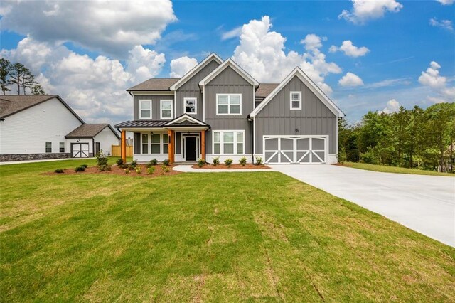 8245 Dawson View Way, Cumming, GA 30028 - view of front facade with board and batten siding, driveway, a front yard, and a standing seam roof