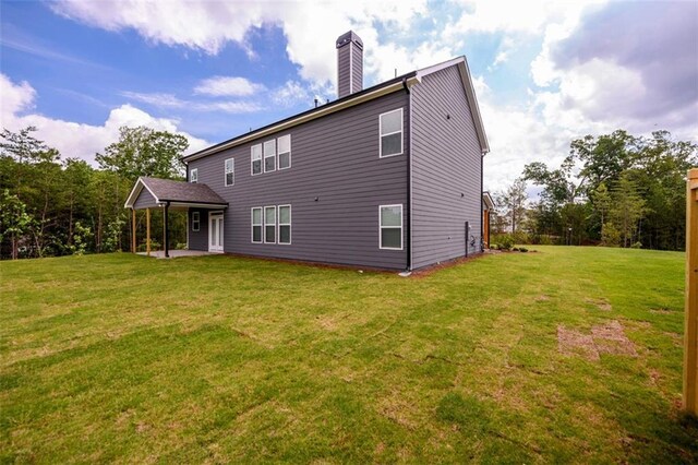 8245 Dawson View Way, Cumming, GA 30028 - rear view of property with a yard, a patio area, and a chimney