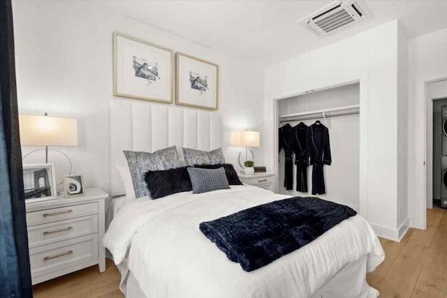 230 New St Unit 2201-4, Decatur, GA 30030 - bedroom with stacked washer / dryer, light wood-style flooring, and a closet