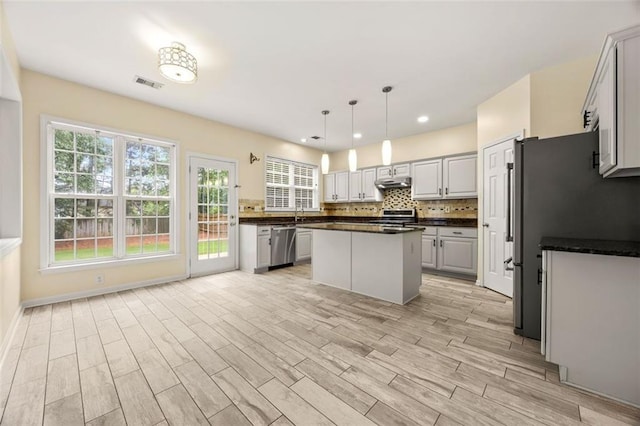 5156 Amberden Hall Dr, Suwanee, GA 30024 - kitchen featuring stainless steel appliances, dark countertops, under cabinet range hood, healthy amount of natural light, and recessed lighting