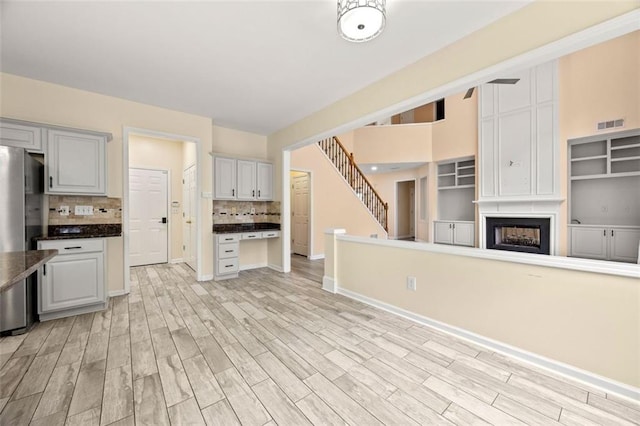 5156 Amberden Hall Dr, Suwanee, GA 30024 - kitchen with freestanding refrigerator, backsplash, light wood-type flooring, baseboards, and open floor plan