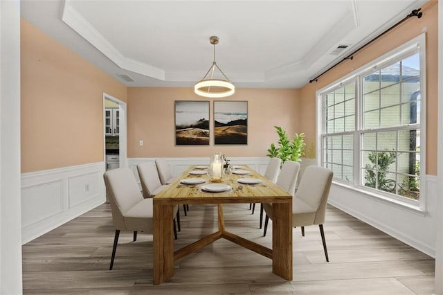 5156 Amberden Hall Dr, Suwanee, GA 30024 - dining space featuring crown molding, a raised ceiling, wood finished floors, wainscoting, and a decorative wall