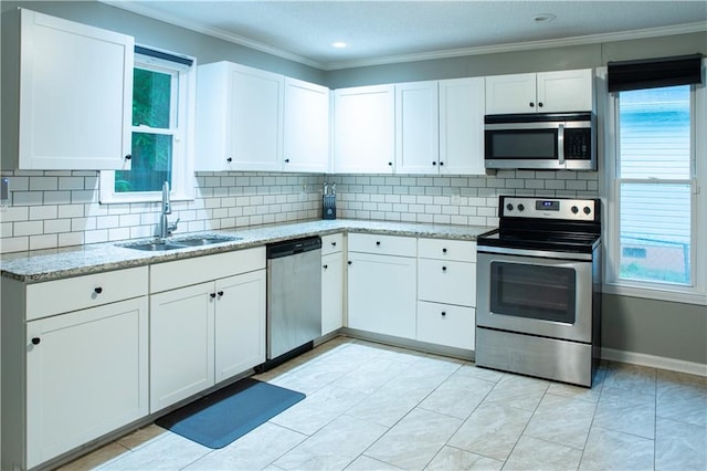 kitchen with stainless steel appliances, white cabinets, sink, backsplash, and light tile patterned flooring