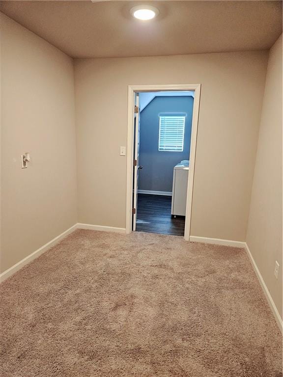 spare room featuring washer / dryer and carpet floors