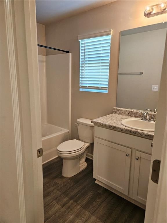 full bathroom featuring vanity, wood-type flooring, toilet, and shower / bath combination