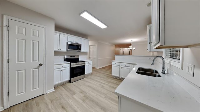 kitchen with white cabinetry, stainless steel appliances, sink, and light hardwood / wood-style flooring