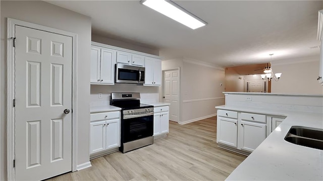 kitchen with pendant lighting, white cabinetry, light hardwood / wood-style floors, stainless steel appliances, and crown molding